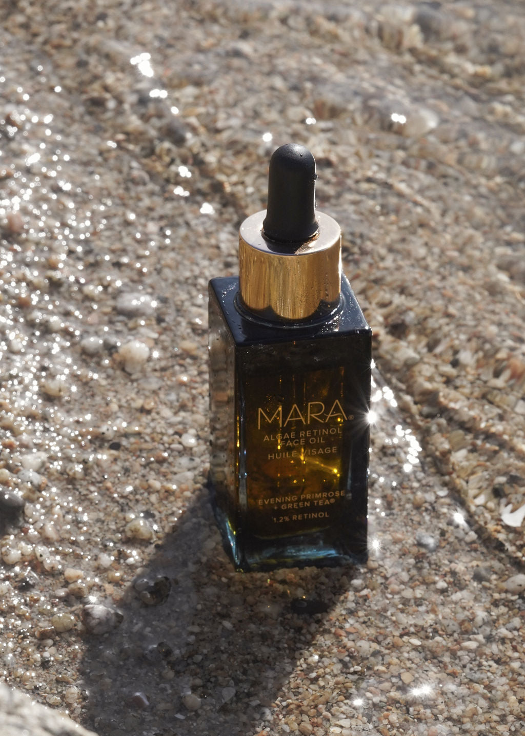 MARA Algae Retinol Face Oil on the shoreline with water