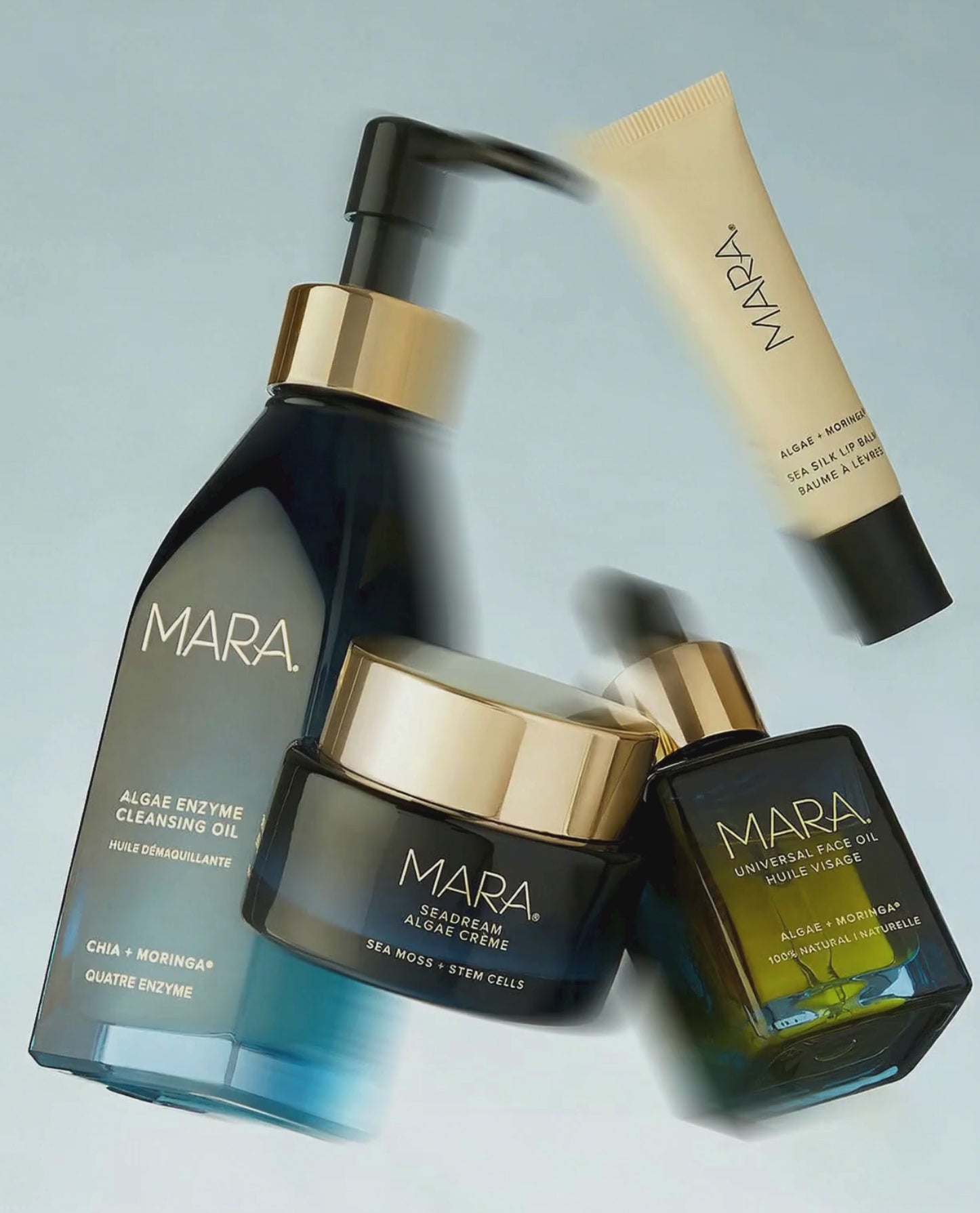 MARA Algae Enzyme Cleansing Oil, SeaDream Algae Creme, Universal Face Oil, Sea Silk Lip Balm floating on blue background