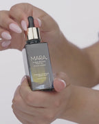 Hand squeezing algae retinol oil into its bottle 