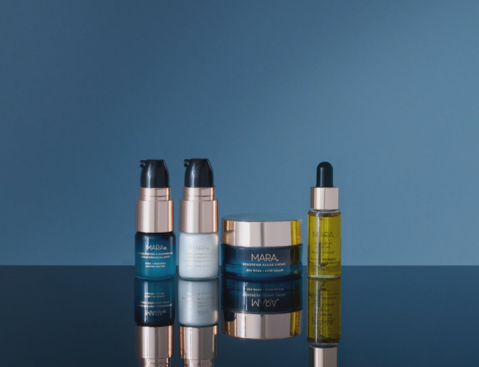 MARA Skincare Intro Set getting splashed with water on blue background. 