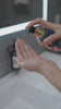 Woman using Aura Cleanse Foaming Gel Cleanser in the bathroom, doing the whole routine